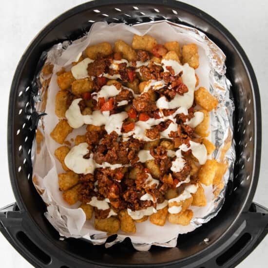 an air fryer filled with nachos and cheese.