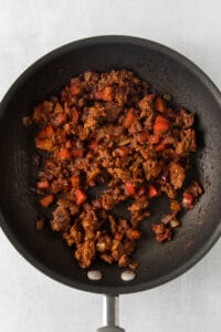 a frying pan filled with meat and vegetables.