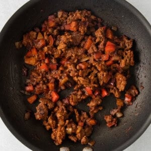 a frying pan filled with meat and vegetables.