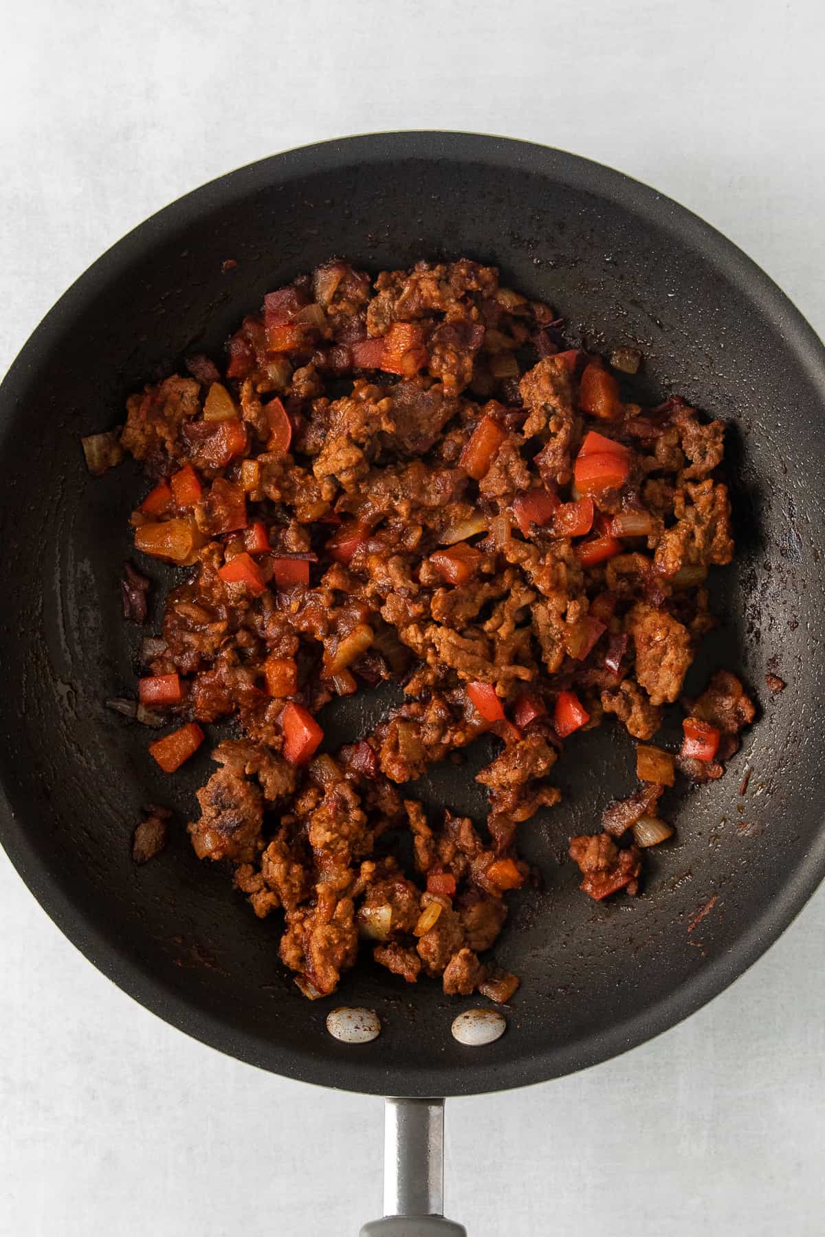 Ground beef and peppers in a skillet.