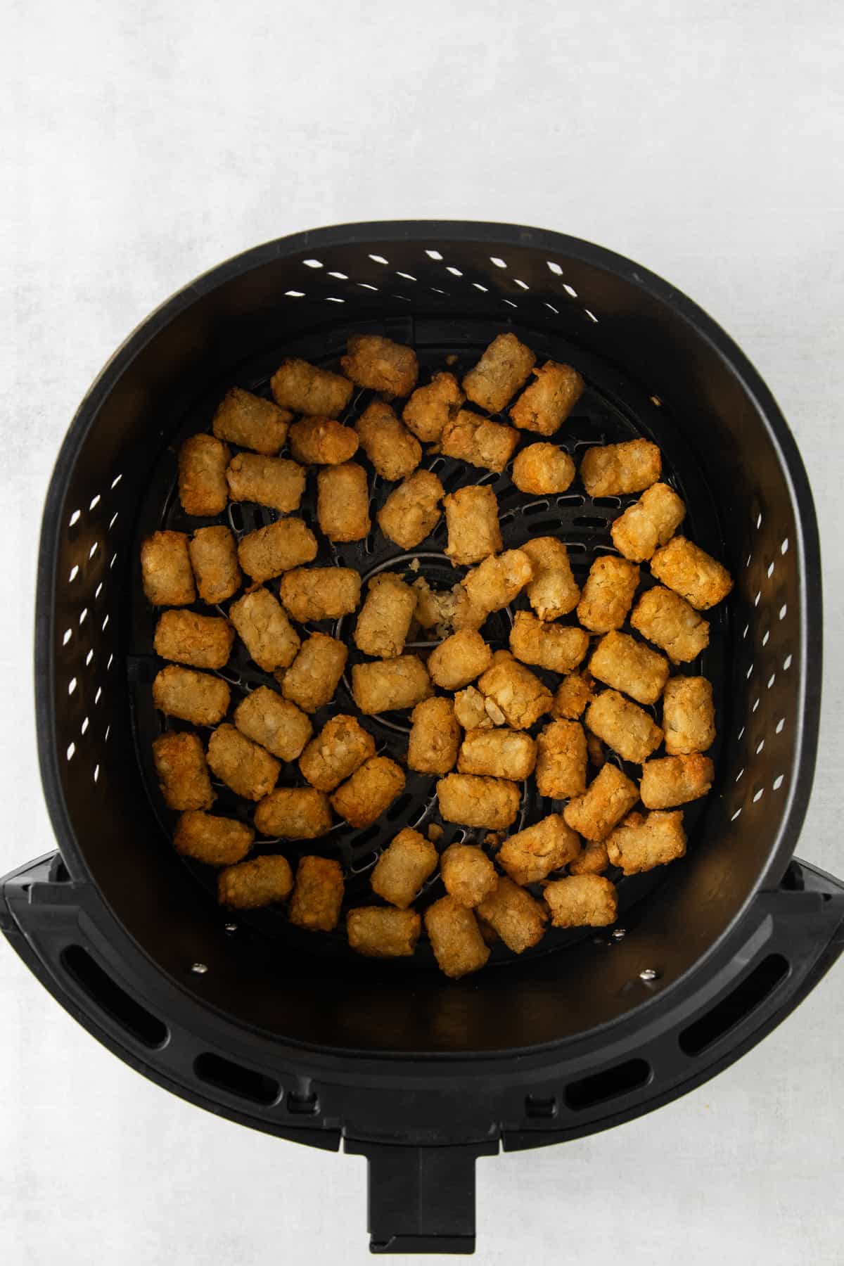 Tater tots in an air fryer.