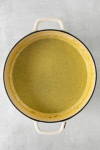 a pot of green soup on a gray background.