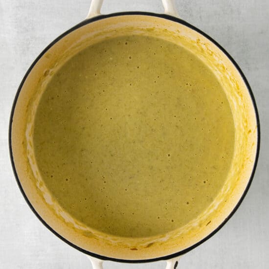 a pot of green soup on a gray background.