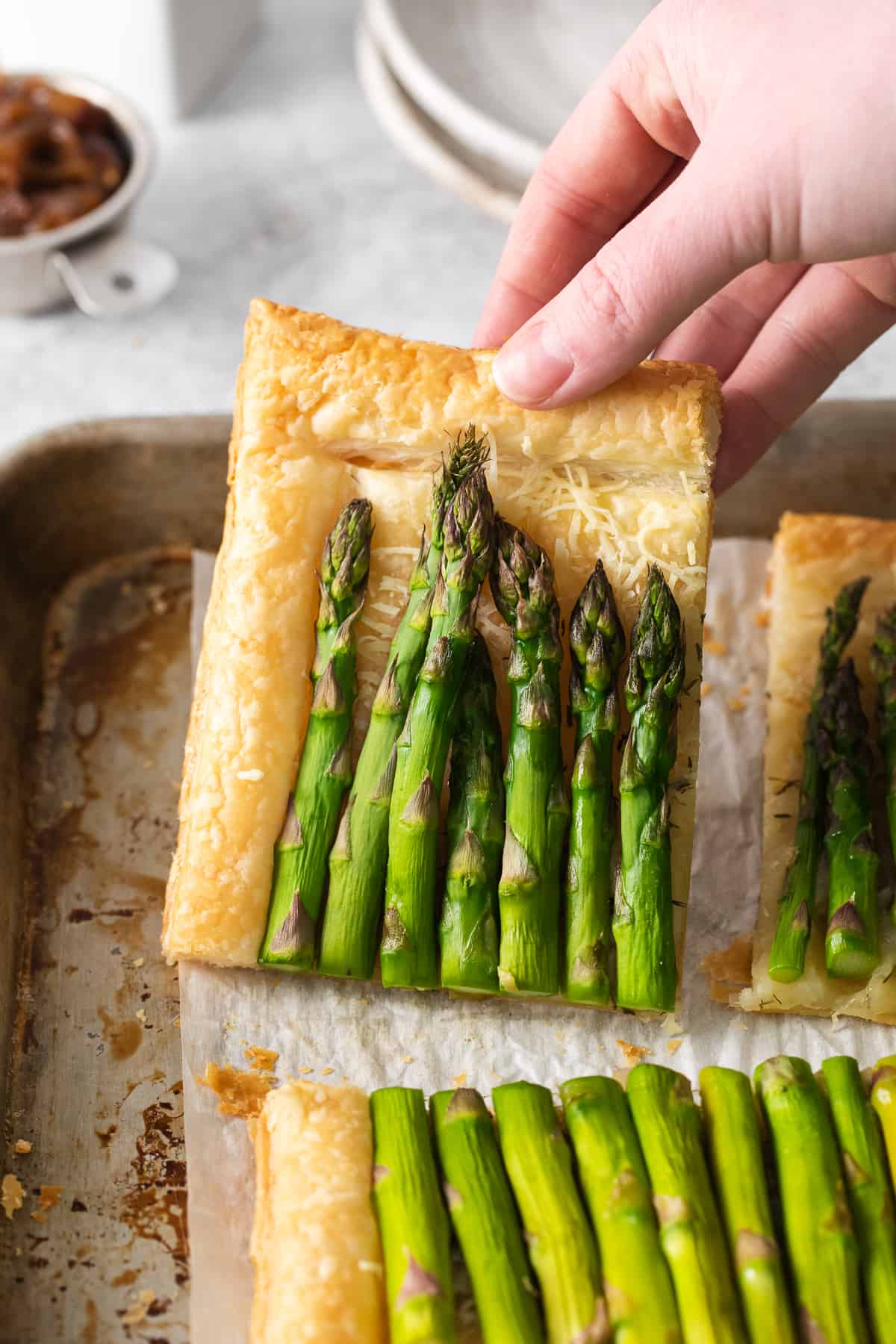 Slice of asparagus tart on a baking sheet.