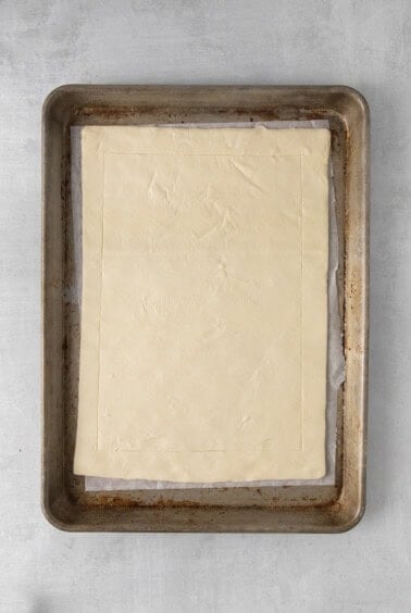a square of pastry dough on a baking sheet.