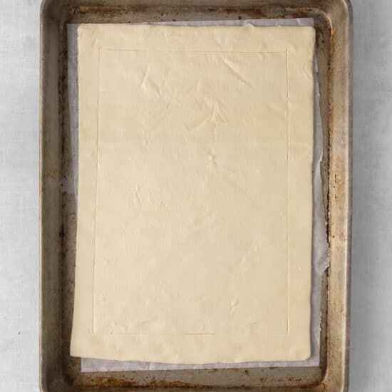 a square of pastry dough on a baking sheet.