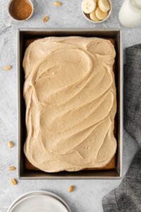 peanut butter banana cake in a pan with frosting and bananas.