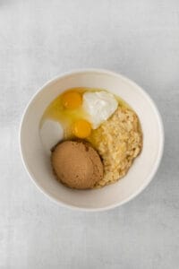 a bowl of oats with an egg and a piece of bread.