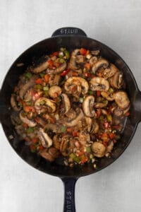 a skillet filled with mushrooms and peppers.