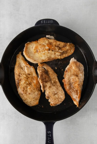 chicken breasts in a skillet on a white background.