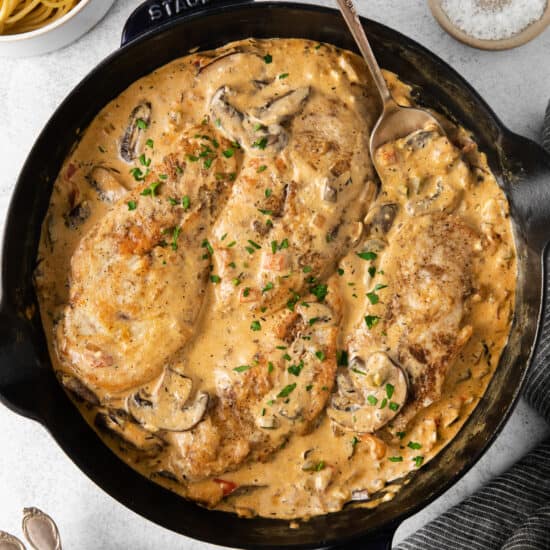 a skillet filled with chicken and mushrooms in a creamy sauce.