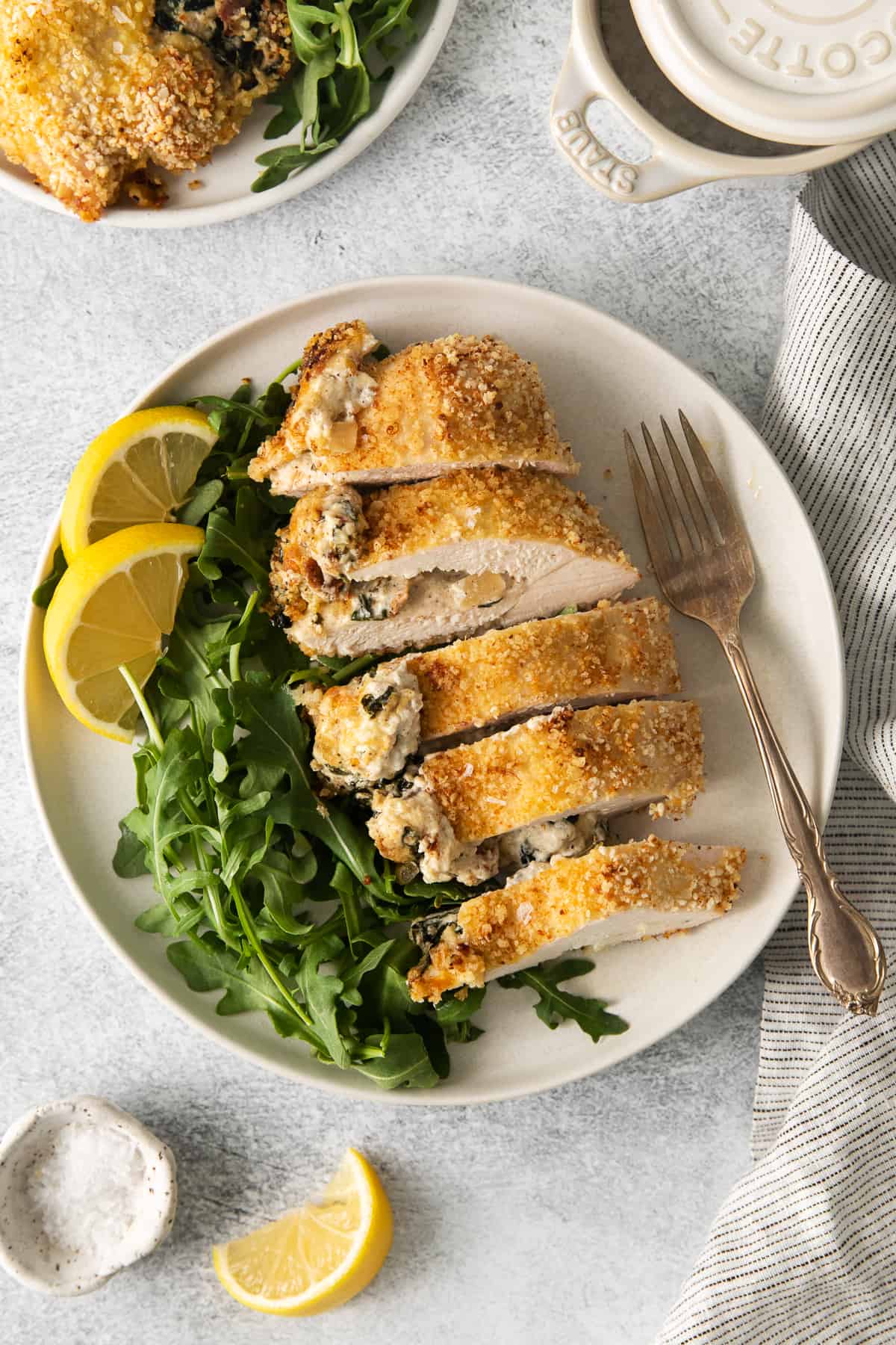 Cream cheese stuffed chicken breast cut in slices on a plate.