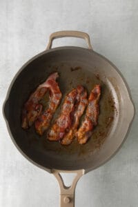a frying pan with bacon in it.