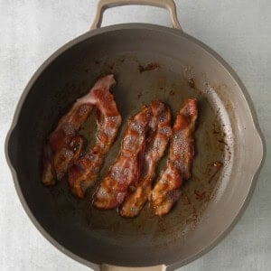 a frying pan with bacon in it.