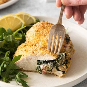 Cream cheese stuffed chicken on a plate.