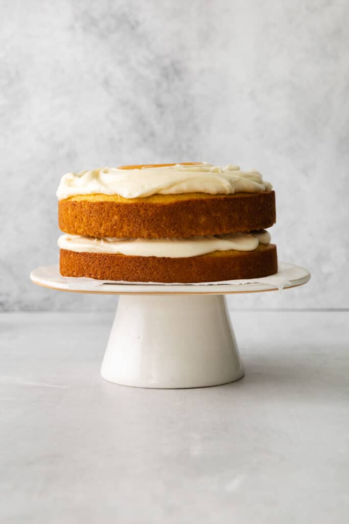 a white cake sitting on a white plate.