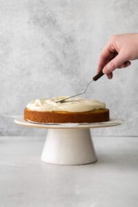 a person cutting a cake with a fork.
