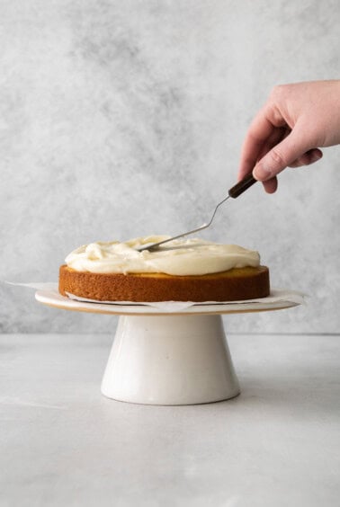 a person cutting a cake with a fork.