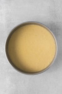 a yellow batter in a metal pan on a grey surface.