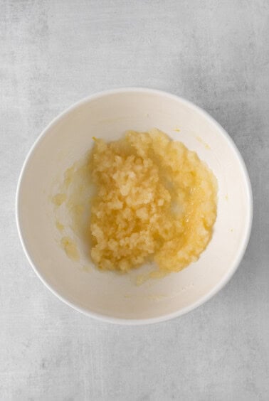 a white bowl with a yellow substance in it.