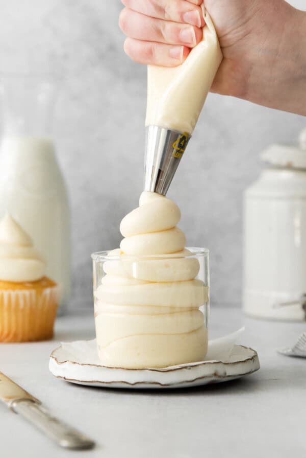 Mascarpone frosting being piped into a glass.