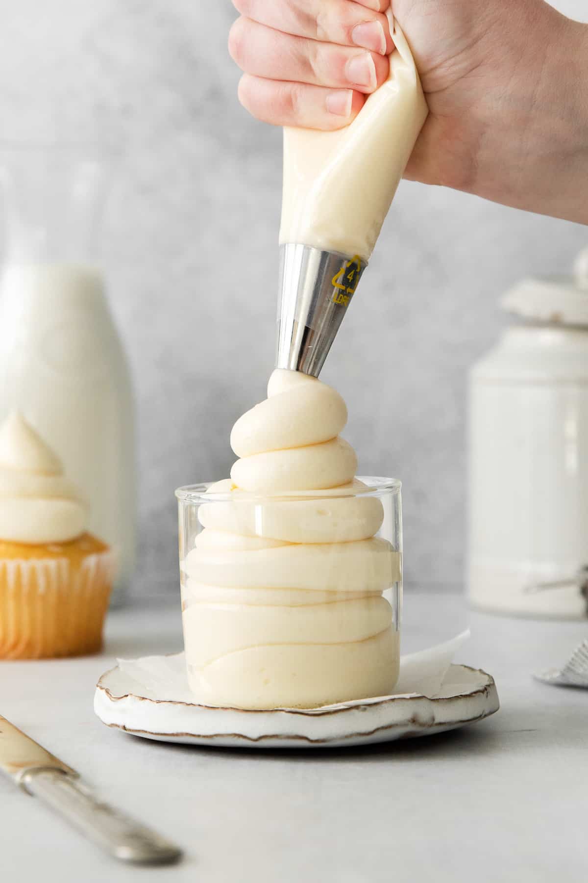 Mascarpone frosting being piped into a glass.