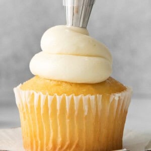 a cupcake is being iced with a buttercream icing.