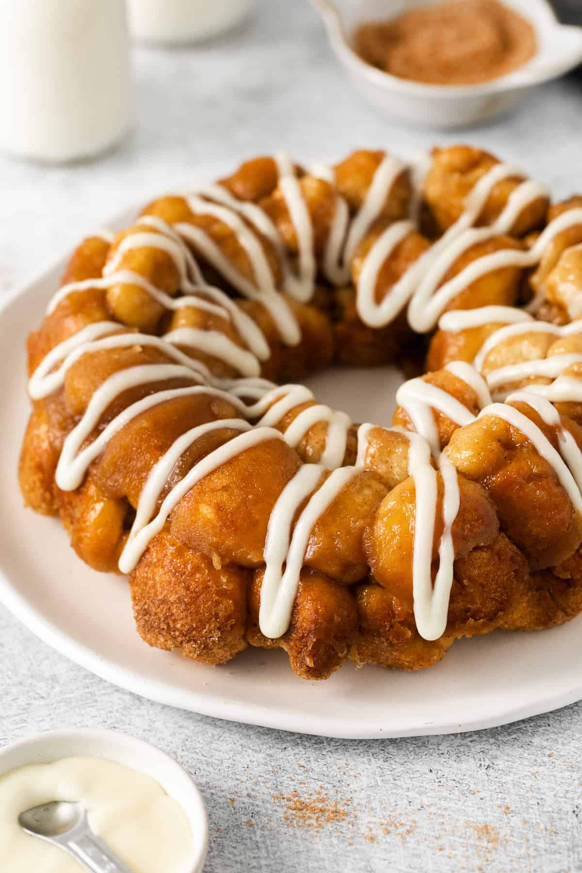 Monkey bread with cream cheese frosting on a plate.
