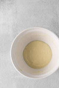 a white bowl with a yellow liquid in it.