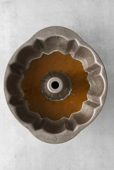 a metal bundt pan with a brown liquid in it.