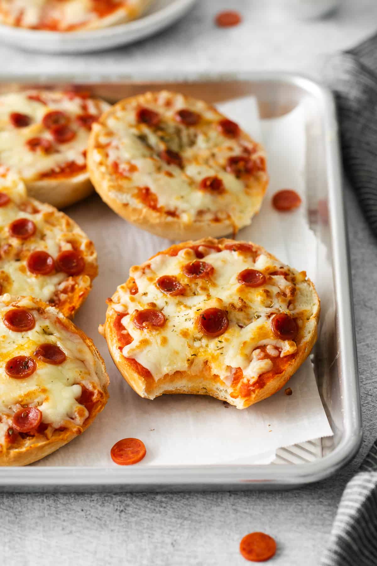 Pizza bagel with a bite taken out of it.
