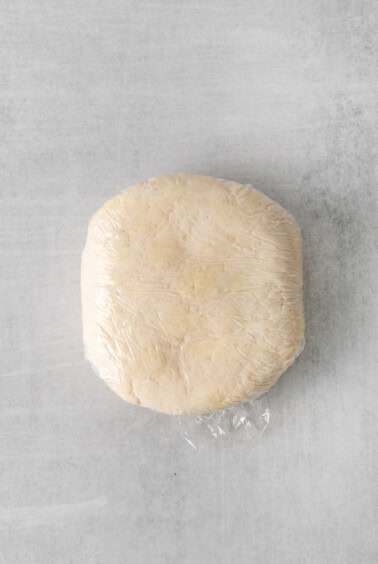 a piece of chicken in a plastic bag on a grey surface.