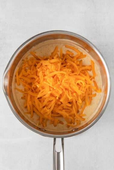 shredded cheese in a pan on a white background.