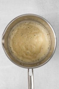 a frying pan full of liquid on a white background.