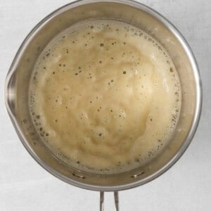 a frying pan full of liquid on a white background.