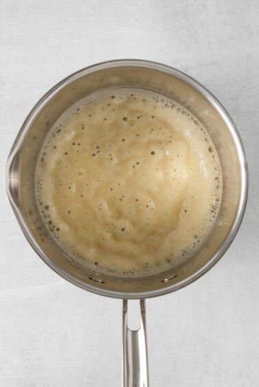 a frying pan full of liquid on a white background.