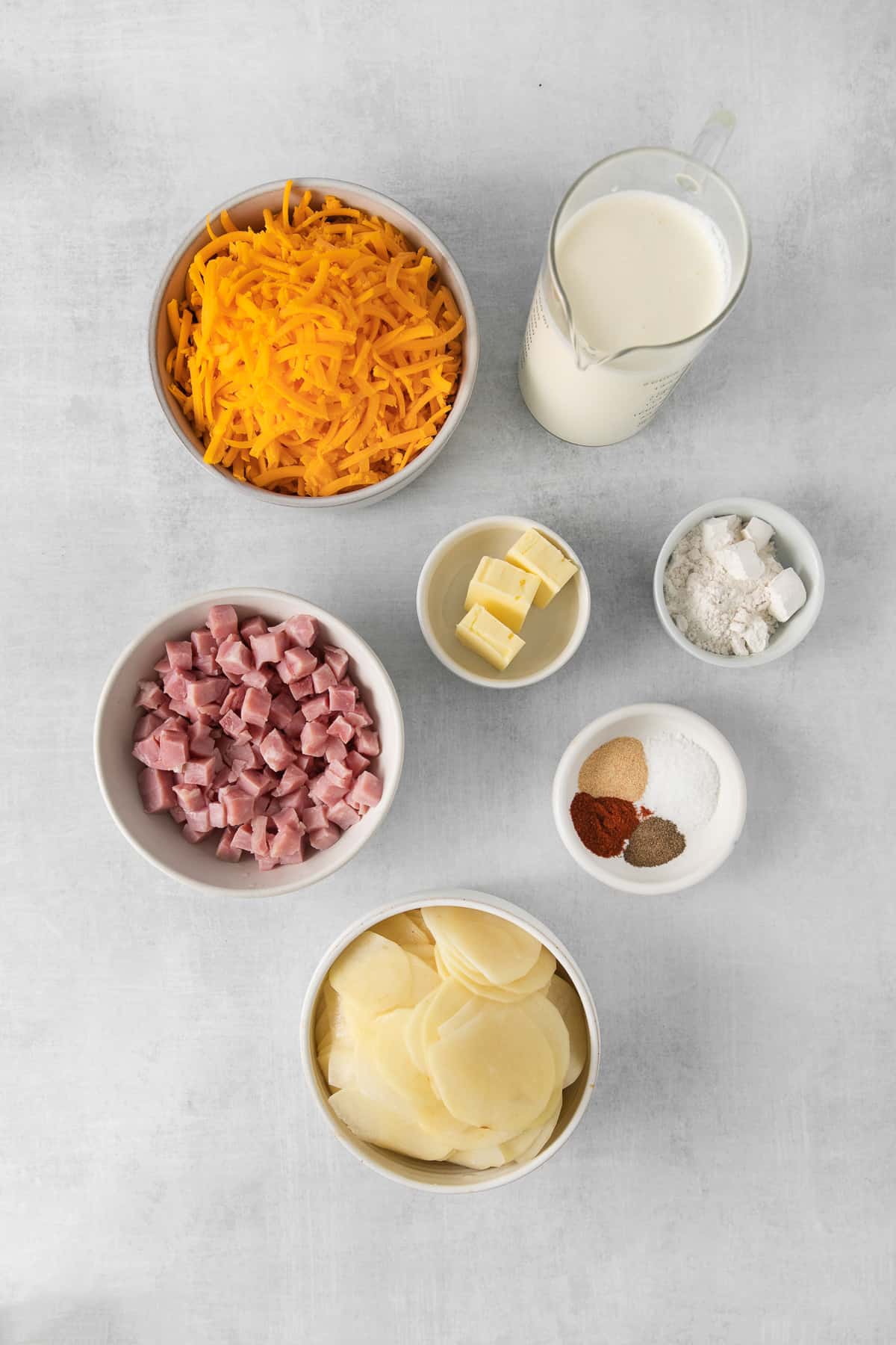 Ingredients for ham and scalloped potatoes in bowls.