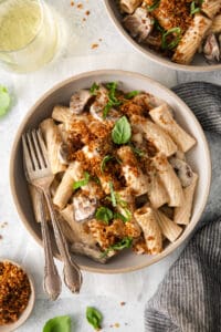 a bowl of pasta with mushrooms and parmesan cheese.