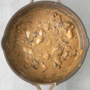 a skillet filled with mushrooms and gravy.