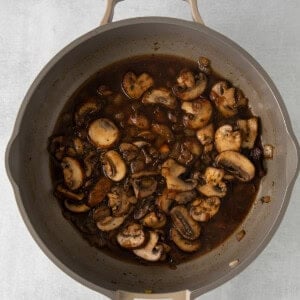 mushroom gravy in a skillet on a white background.