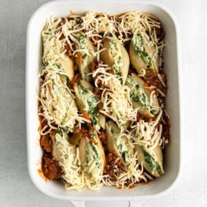 cheesy stuffed shells in a white baking dish.