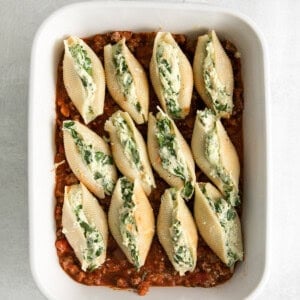 stuffed shells in a white baking dish.