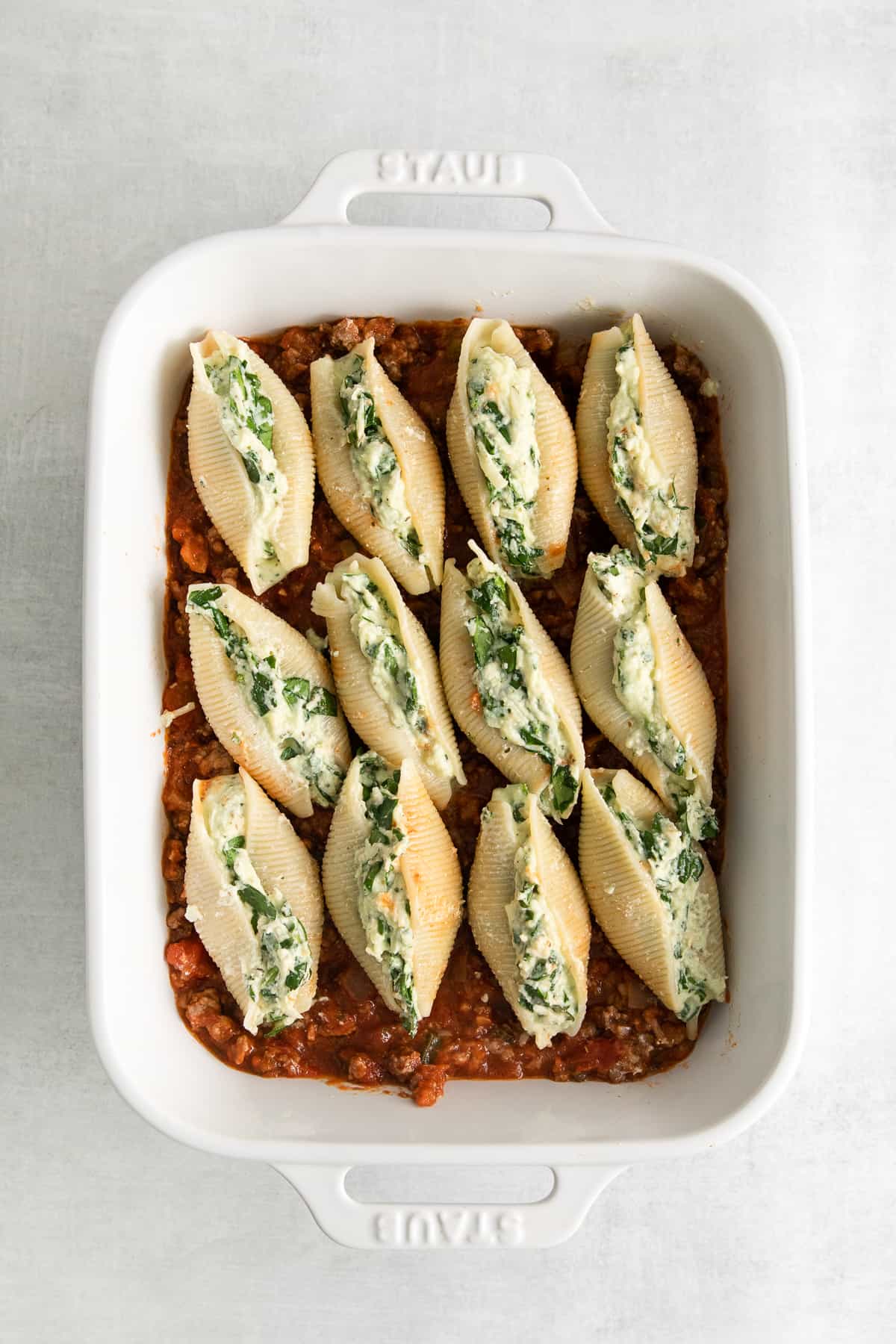 Stuffed shells with meat sauce in a casserole dish.