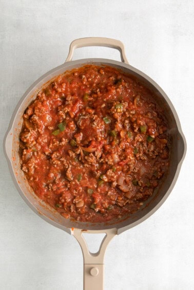 a skillet filled with meat and tomato sauce.