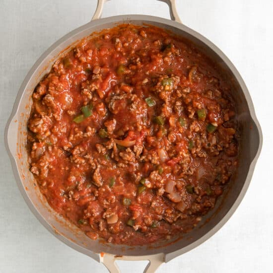 a skillet filled with meat and tomato sauce.