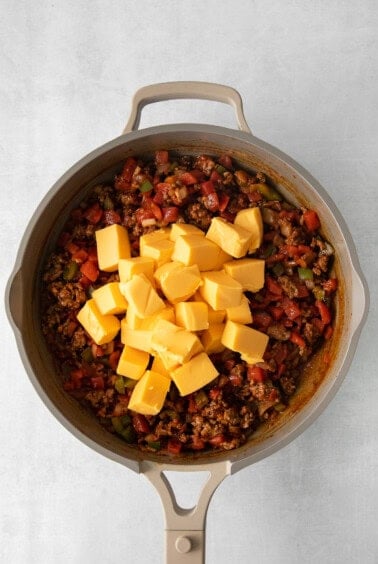 a skillet filled with meat and cheese.