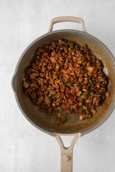 a skillet filled with meat and vegetables.