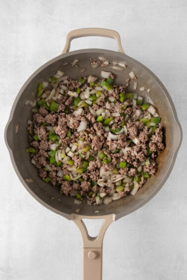 a frying pan filled with meat and onions.