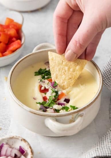 Cotija queso dip in a bowl on a chip.