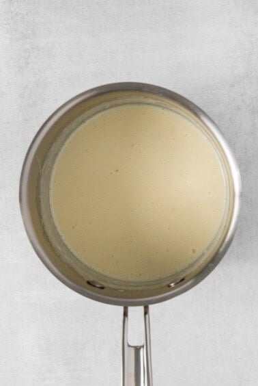 a pan with a white liquid on a white background.